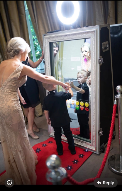 Guests using the magic mirror photobooth at a wedding